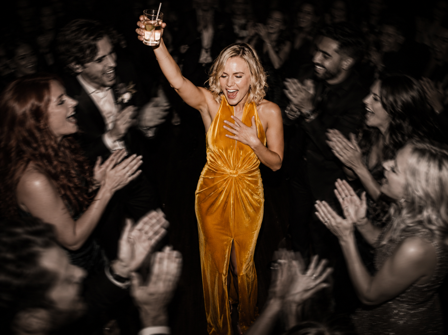 Event guest celebrating with a drink in a lively crowd
